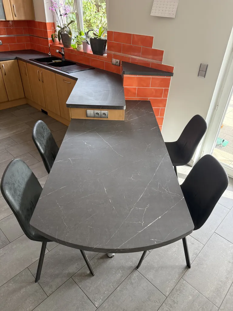 Modification de la couleur d'un plan de travail avec la pose d'un adhésif noir effet marbre pour une cuisine à Duppigheim