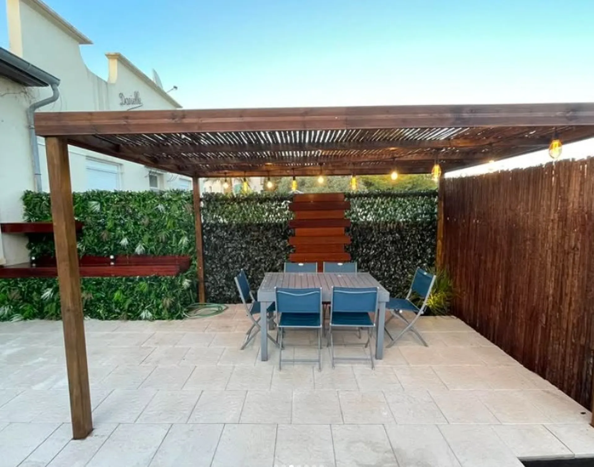 Aménagement extérieur complet à Frontignan : terrasse en dalle, pergola bois sur mesure et brise-vue design par Les Jardins d’Ailleurs