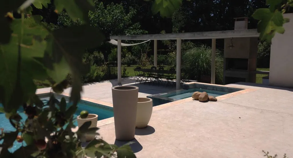 Vue du coin repas - barbecue - piscine avec spa à débordement et pool house