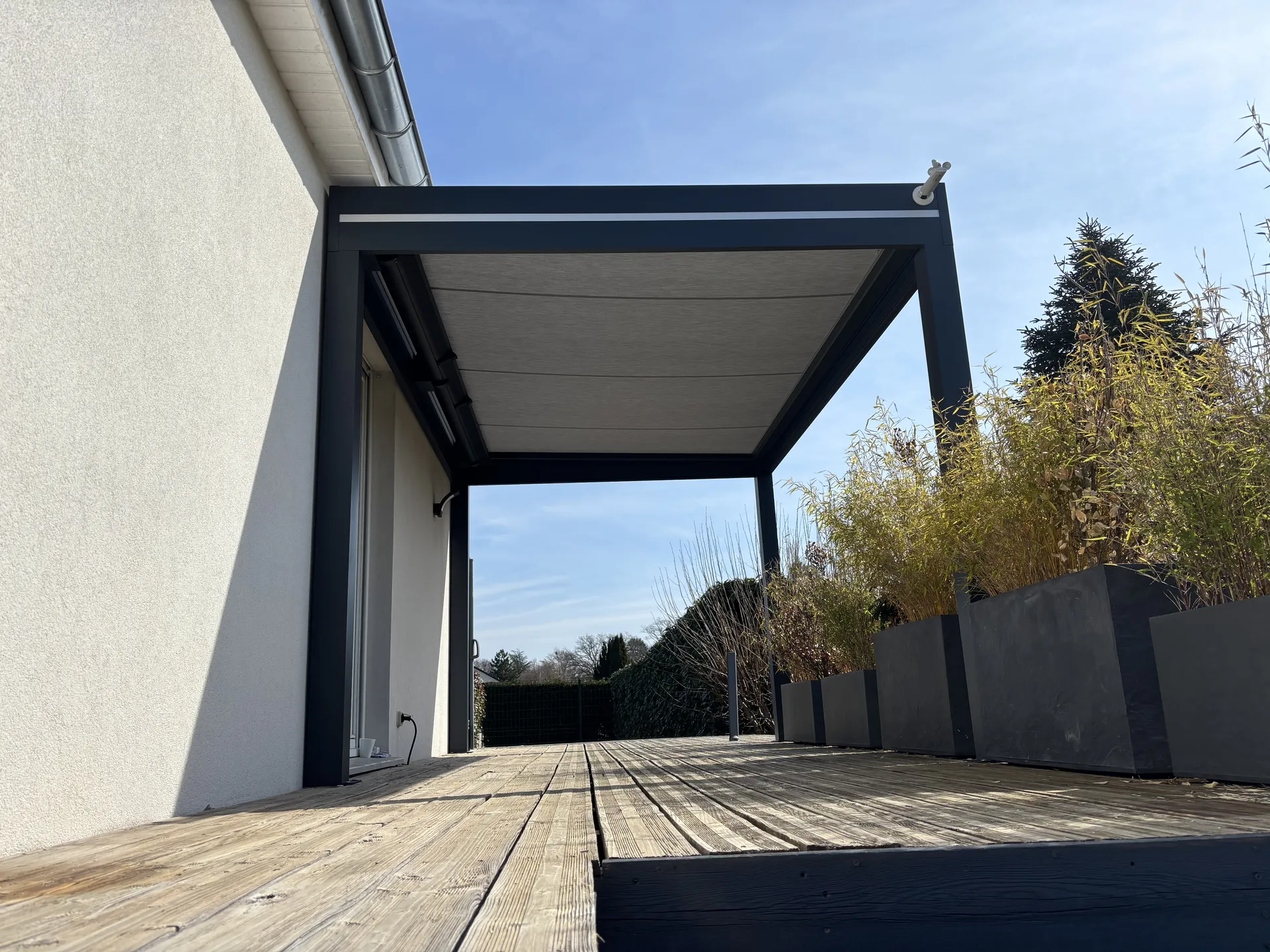 Réalisation d’une pergola store  dans le Territoire de Belfort à  Sermamagny 90300 coloris 7016, toiles Dickson imperméable couleur gris souris