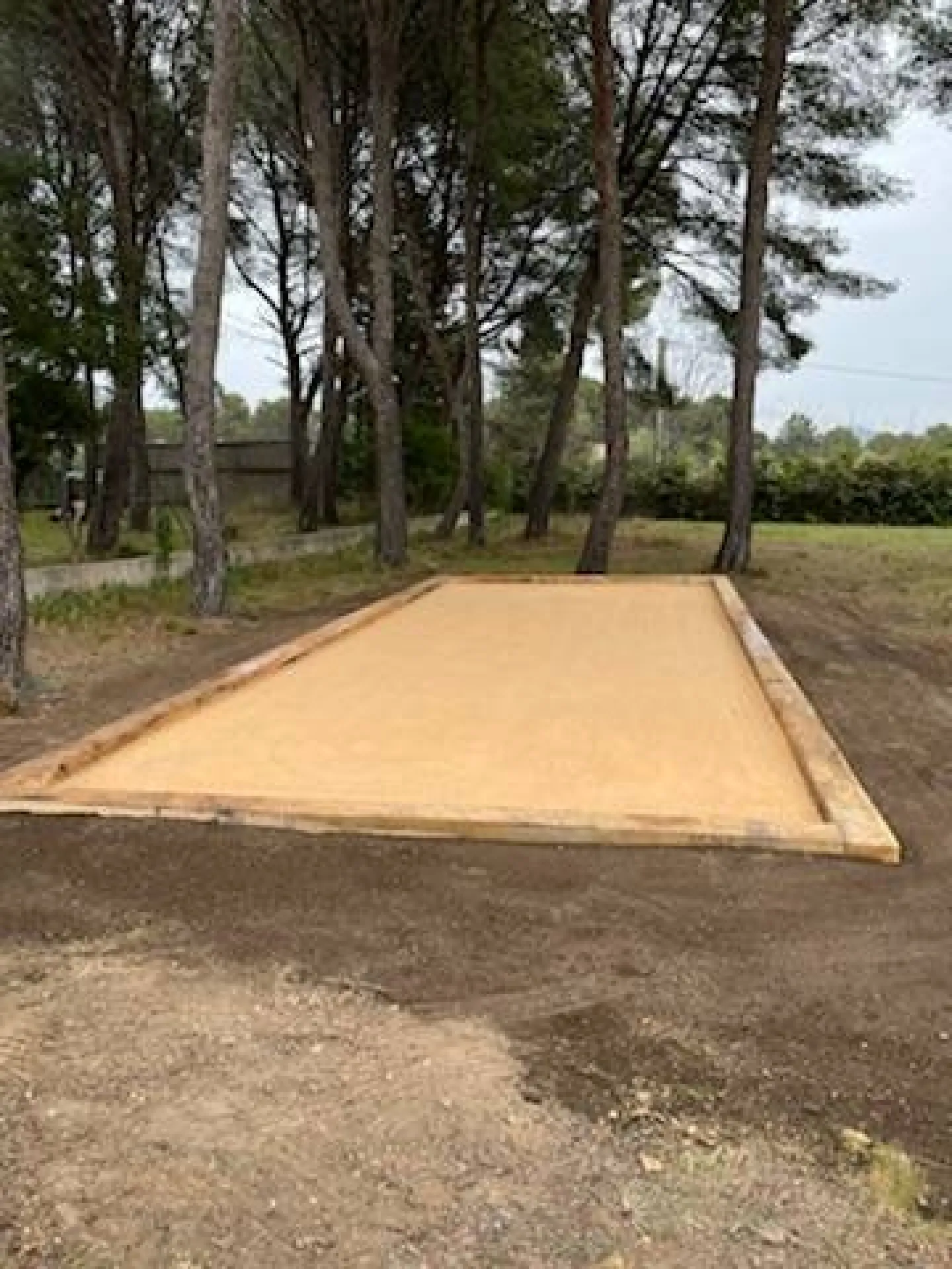 Création d’un terrain de pétanque sous une pinède pour une maison à Velaux près d'Aix en Provence