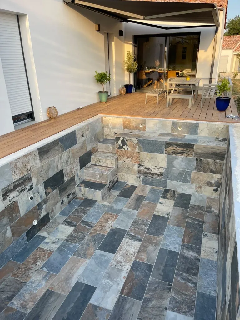 Le carrelage imitation pierre de Bali est idéal pour les plages de piscine : disponible dans nos magasins proches de Rouen et Dieppe.