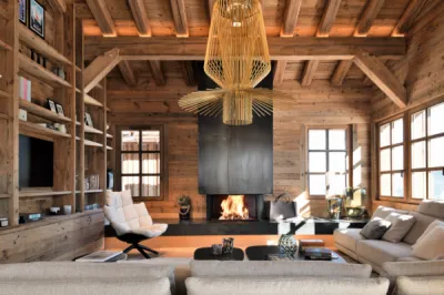 Création d’un espace coin feu en vieux bois à Megève entre charpente traditionnelle et bibliothèque sur mesure