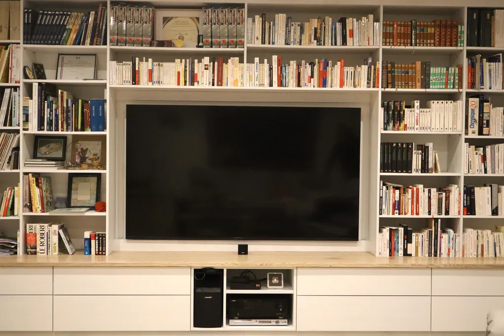 Un meuble TV sur mesure intégré à une biblio-cinémathèque contemporaine pensée pour un espace culturel en Ardèche