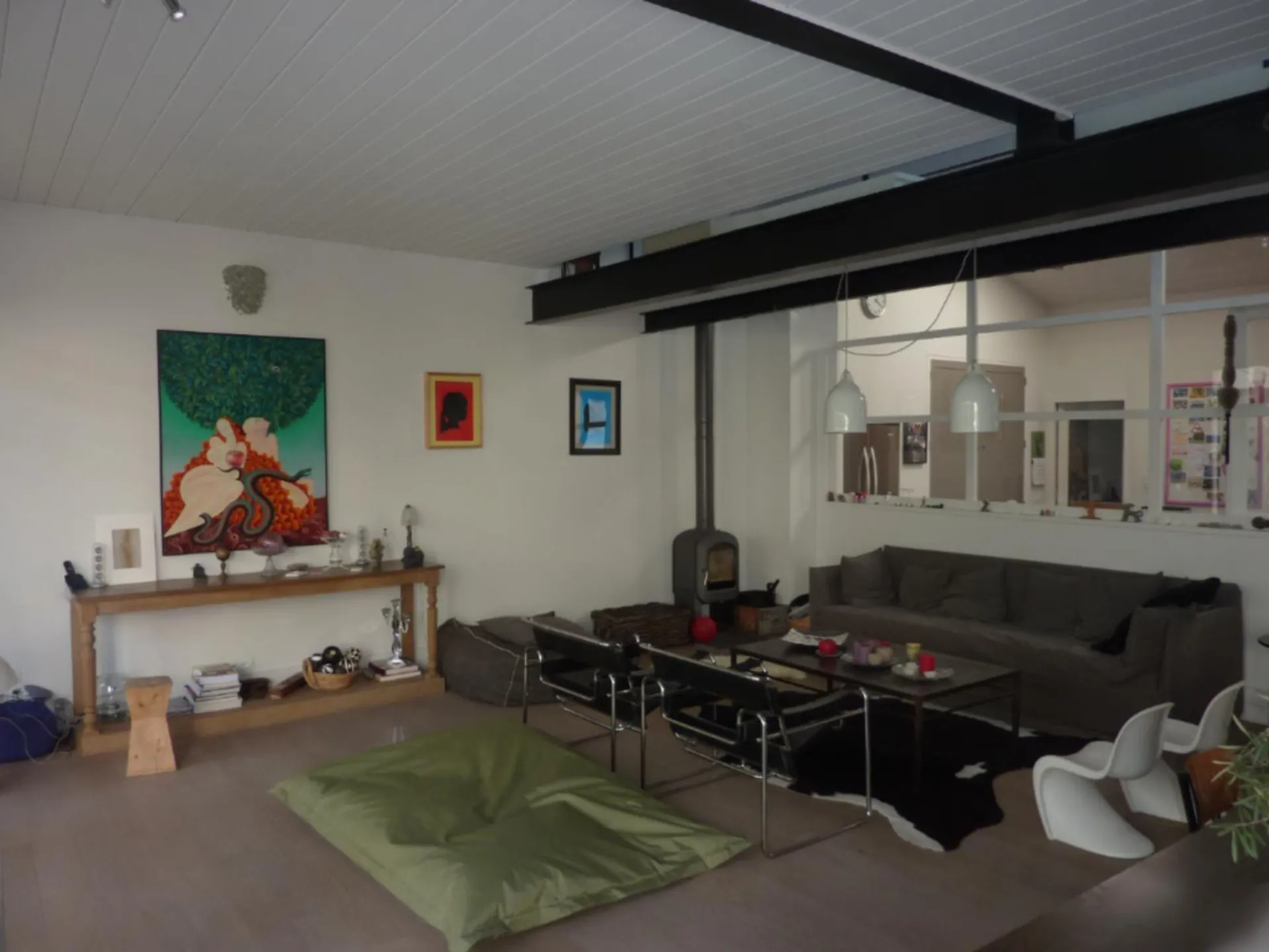 Verrière d’atelier installée entre la cuisine et le salon dans une maison à Lyon (Rhône – 69) pour structurer l’espace et apporter plus de luminosité