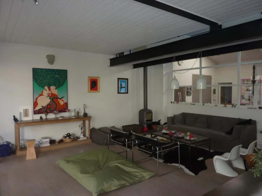 Verrière d’atelier installée entre la cuisine et le salon dans une maison à Lyon (Rhône – 69) pour structurer l’espace et apporter plus de luminosité