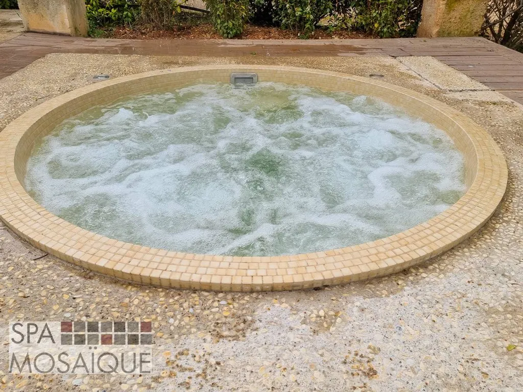 Un spa mosaïque carrelé encastré dans une terrasse en béton à Aix-en-Provence