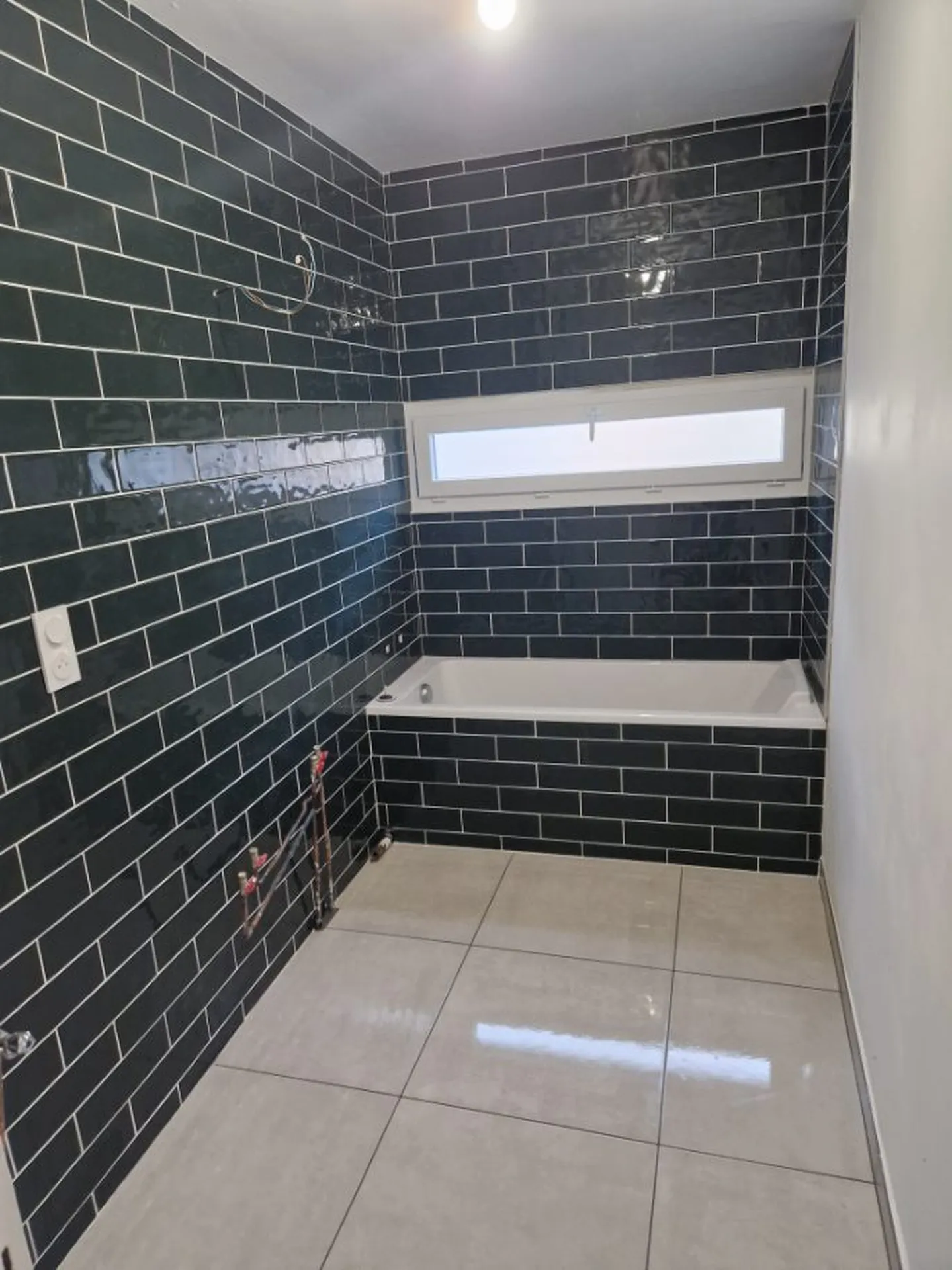 Travaux de carrelage des murs et du sol lors de la rénovation complète de cette salle de bain à Lyon (Rhône – 69), avec pose de faïence et carrelage pour une finition moderne et durable