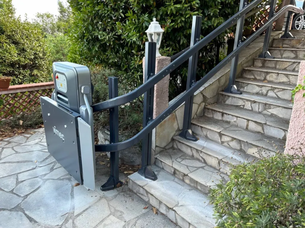 Une fois repliée, la plateforme oblique VIMEC V6 S est d'une discrétion totale dans cet escalier courbe extérieur près de Nice