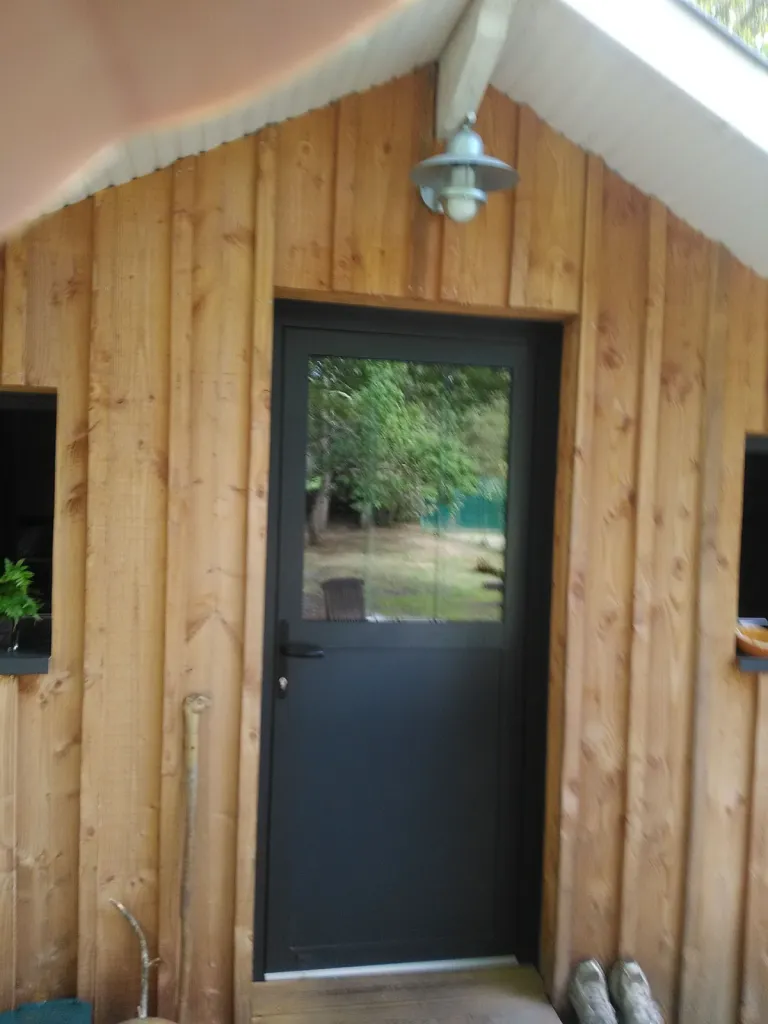 Pose d’une porte d’entrée en alu noir avec vitrage sur une ossature en bois à Pessac