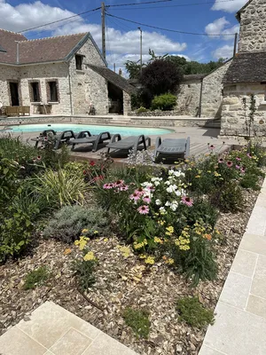 Rénovation des abords d’une piscine à Villemaréchal : terrasse bois, pierre du Sinaï et massifs paysagers
