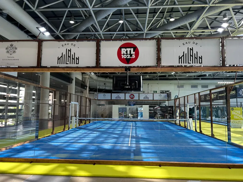 Rénovation d'un terrain de padel intérieur à Nice dans les Alpes-Maritimes : revêtement en gazon synthétique bleu et parois vitrées par Service Tennis