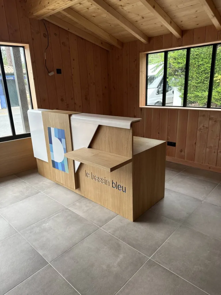 Banque d'accueil, bureau et toile rétro-éclairée dans un commerce  à LEGE CAP FERRET (33)