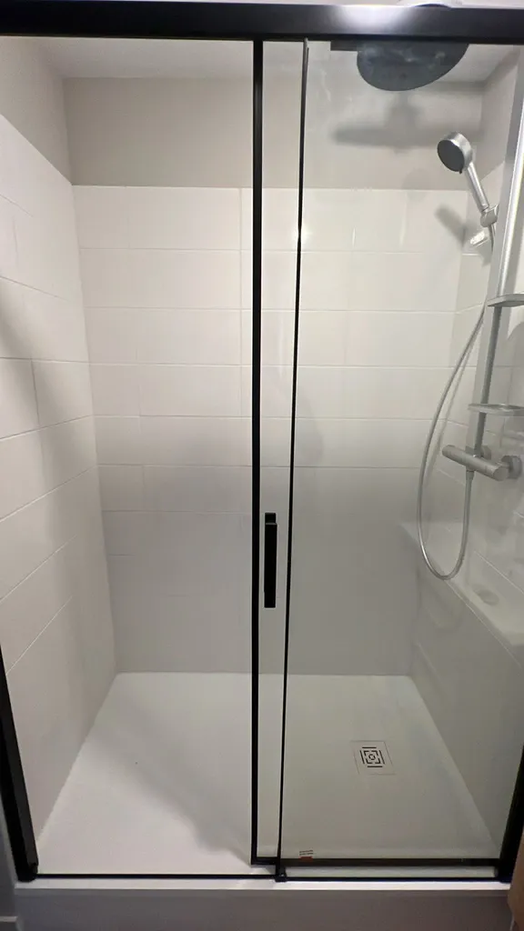 Plombier pour rénovation salle de douche Le Havre : remplacement meuble vasque et douche moderne avec porte coulissante