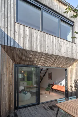 Extension en bois Kebony imaginée par AKIKO ARCHITECTURE, transformant une échoppe bordelaise du quartier Nansouty avec une large ouverture vitrée connectée à la terrasse