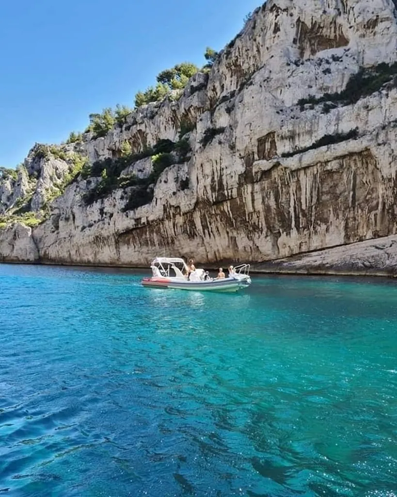 Skipper professionnel de L'Eden Boat au gouvernail d'un semi-rigide naviguant vers les Calanques avec un groupe privatisé pour un EVJF