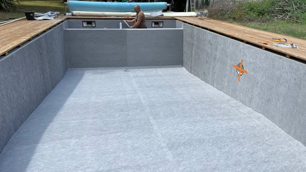 Poseur de membrane 90/100 Alkor sur piscine à Pauillac : soudure à l'air chaud des lès d'étanchéité et brides vers Saint-Estèphe