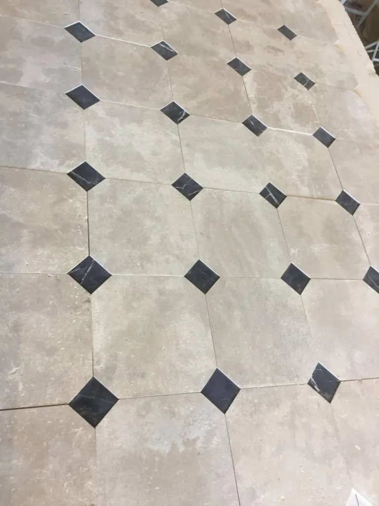 Dallage en pierre naturelle clair vieilli avec cabochon noir