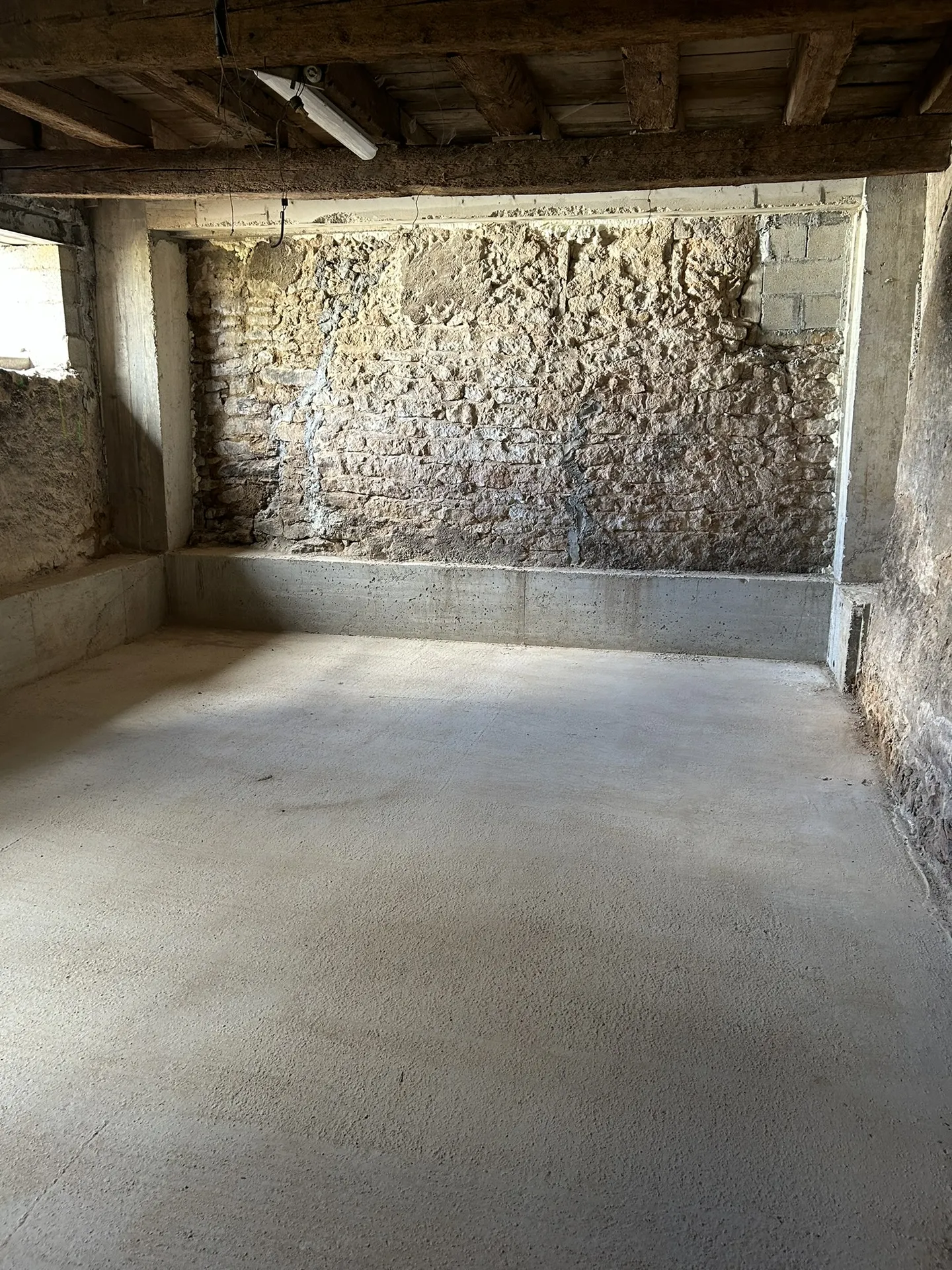 Réalisation d’une dalle en béton après décaissement du sol lors de travaux de maçonnerie dans une maison à Anse (Rhône – 69)