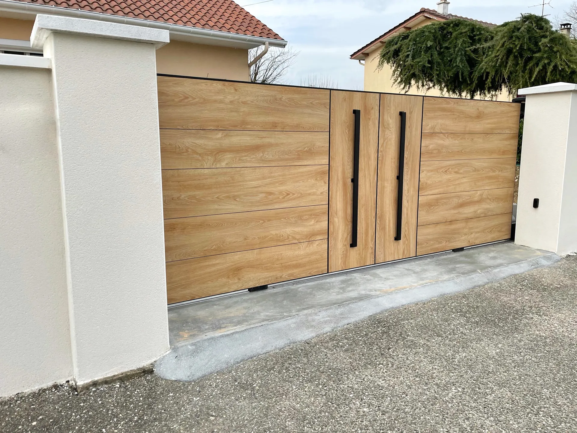 Portail en aluminium ton bois WOODSTOCK bluffant de réalisme assurent une résistance aux UV. La motorisation dans le poteau