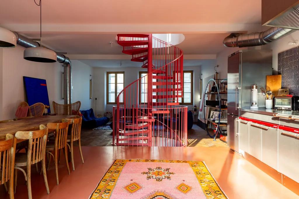 Espace de vie réinventé par AKIKO ARCHITECTURE : cuisine ouverte, matières brutes et escalier rouge iconic, au cœur du projet de surélévation à Bordeaux Nansouty