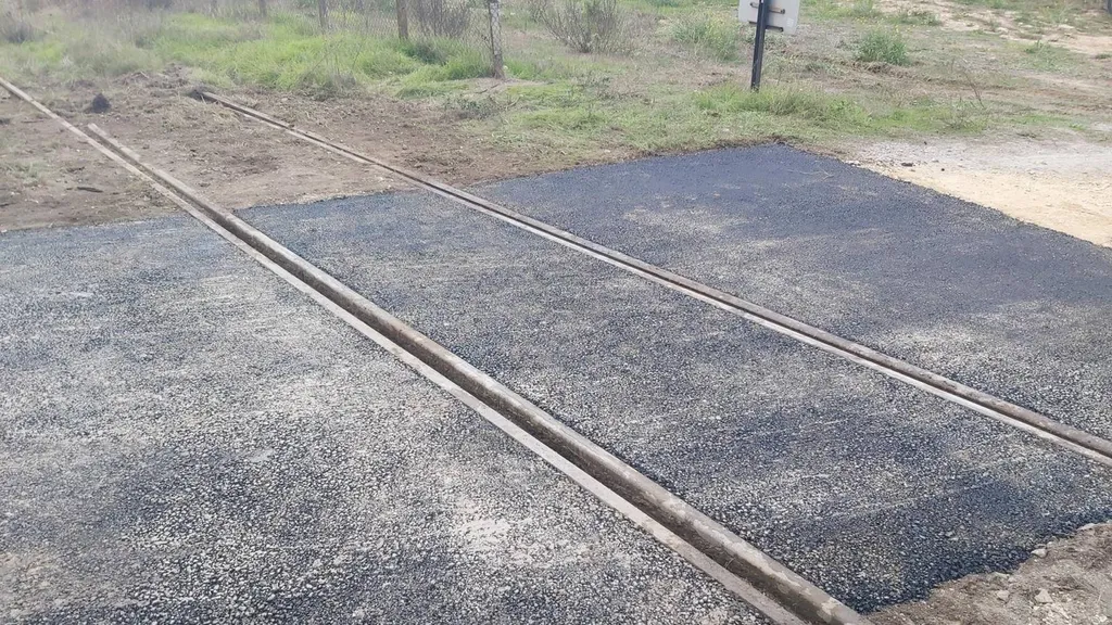 Remise en état d'un passage à niveau en enrobé de bitume noir à Meyreuil dans les Bouches du Rhône.