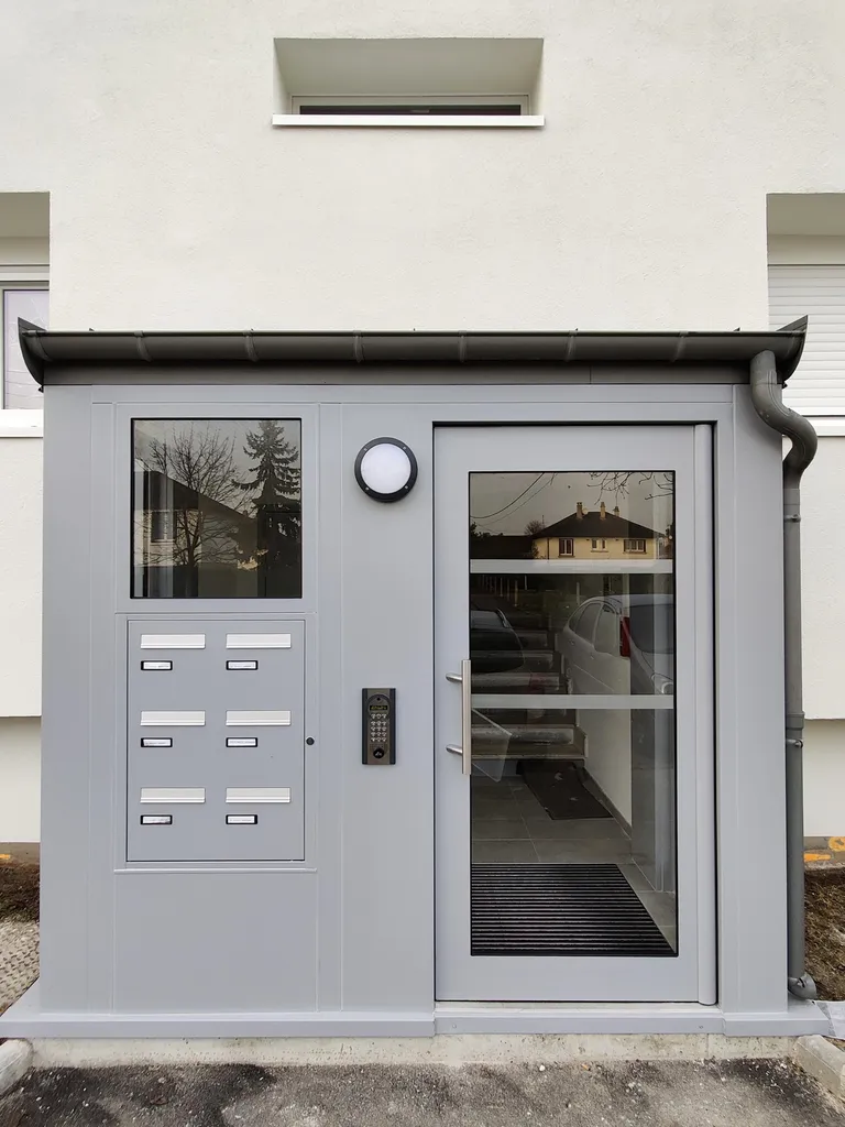 Porte de hall inox sur pivot pour copropriétés avec boîtes aux lettres