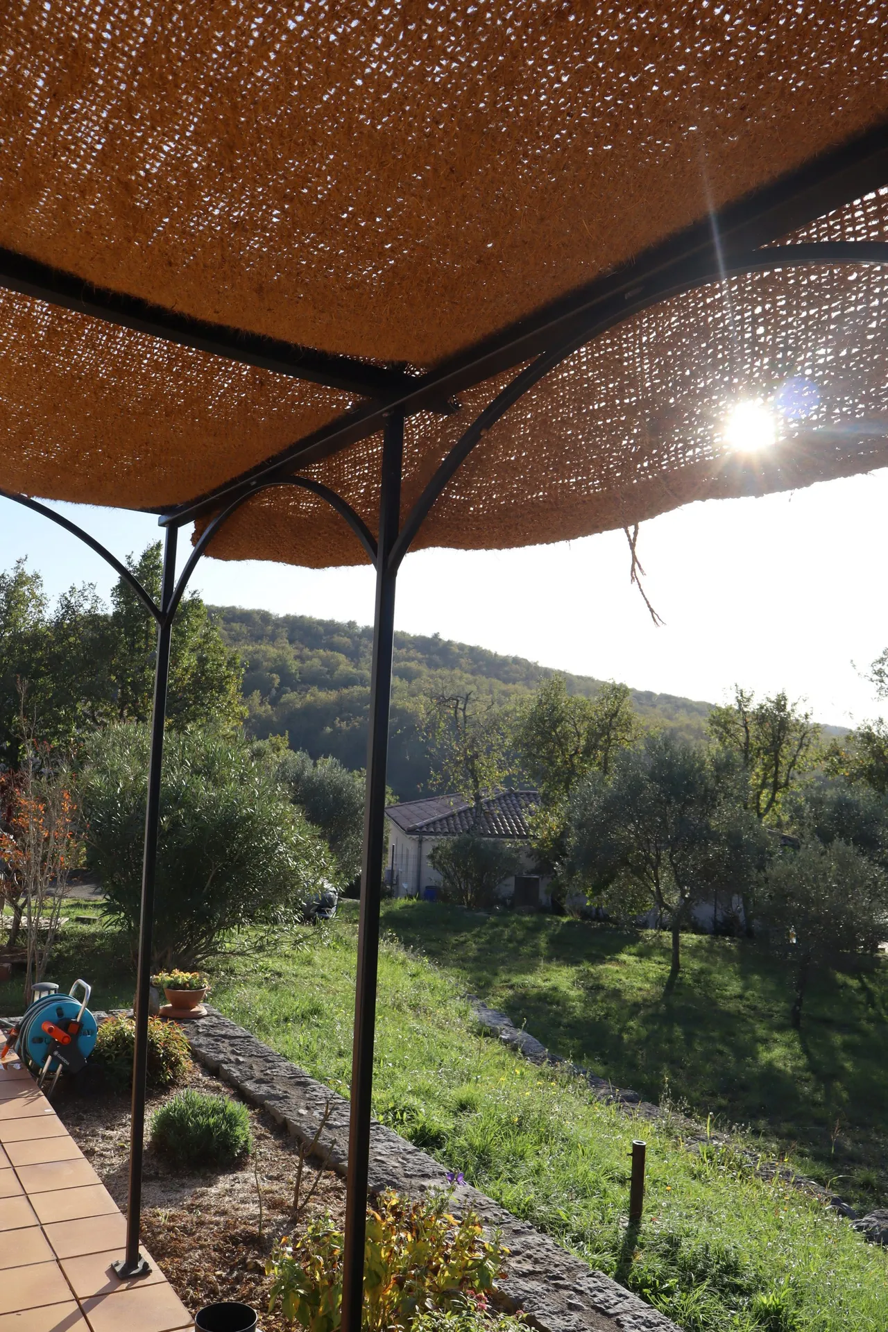 Pergola en fer forgé avec une toile de jute à Pradons en Ardèche pour l'été.