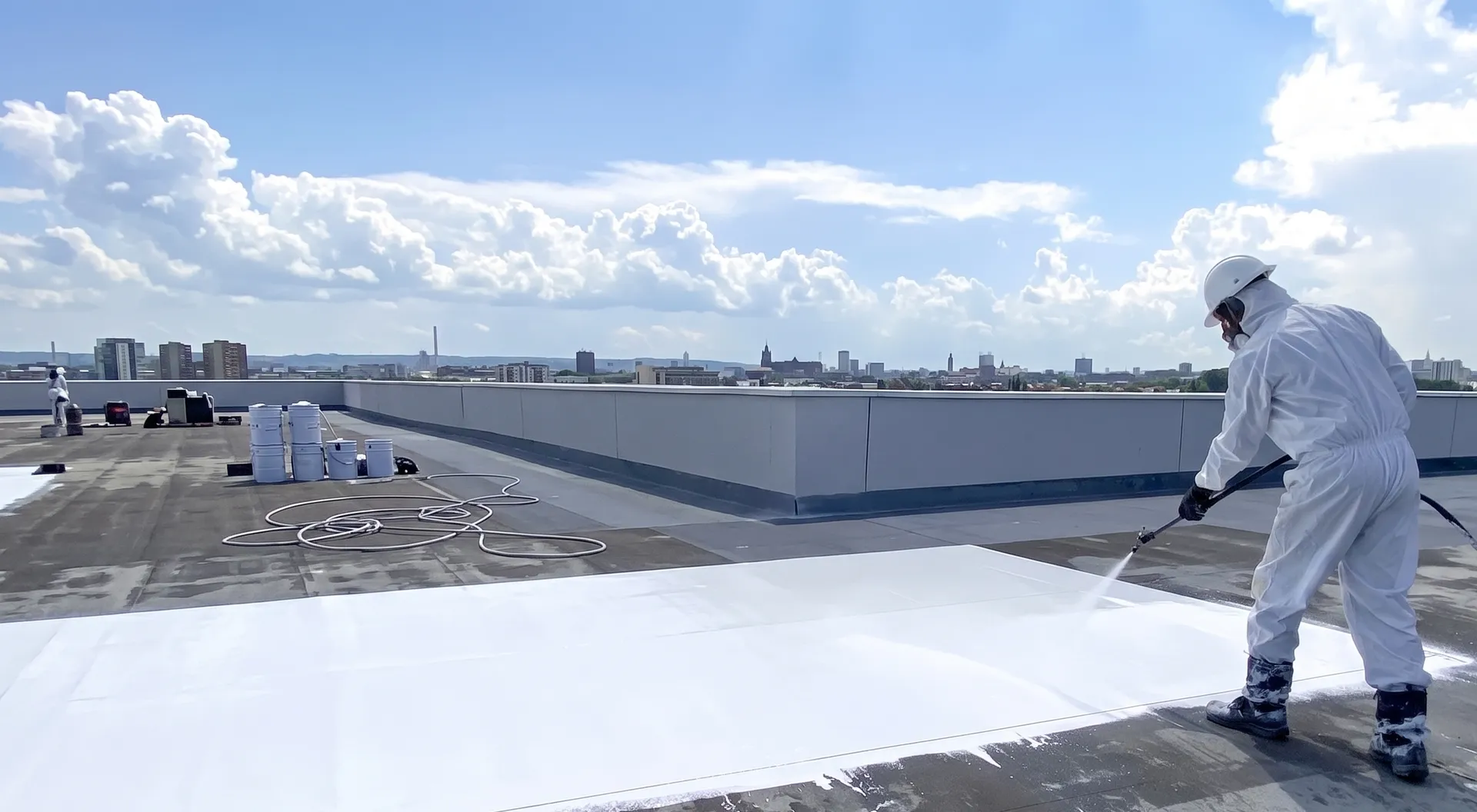 Application par projection d'un revêtement d'étanchéité blanc réflectif (Cool Roof) sur un bâtiment tertiaire à Toulouse