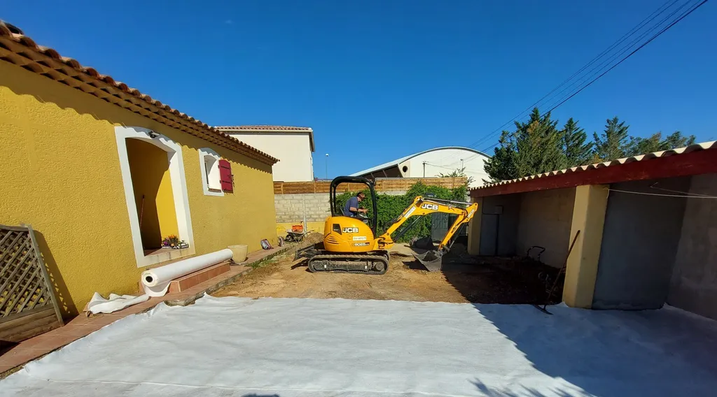 Application d'enrobé de bitume noir dans la cour d'une villa à Saint-Maximin la Sainte-Baume, dans le Var