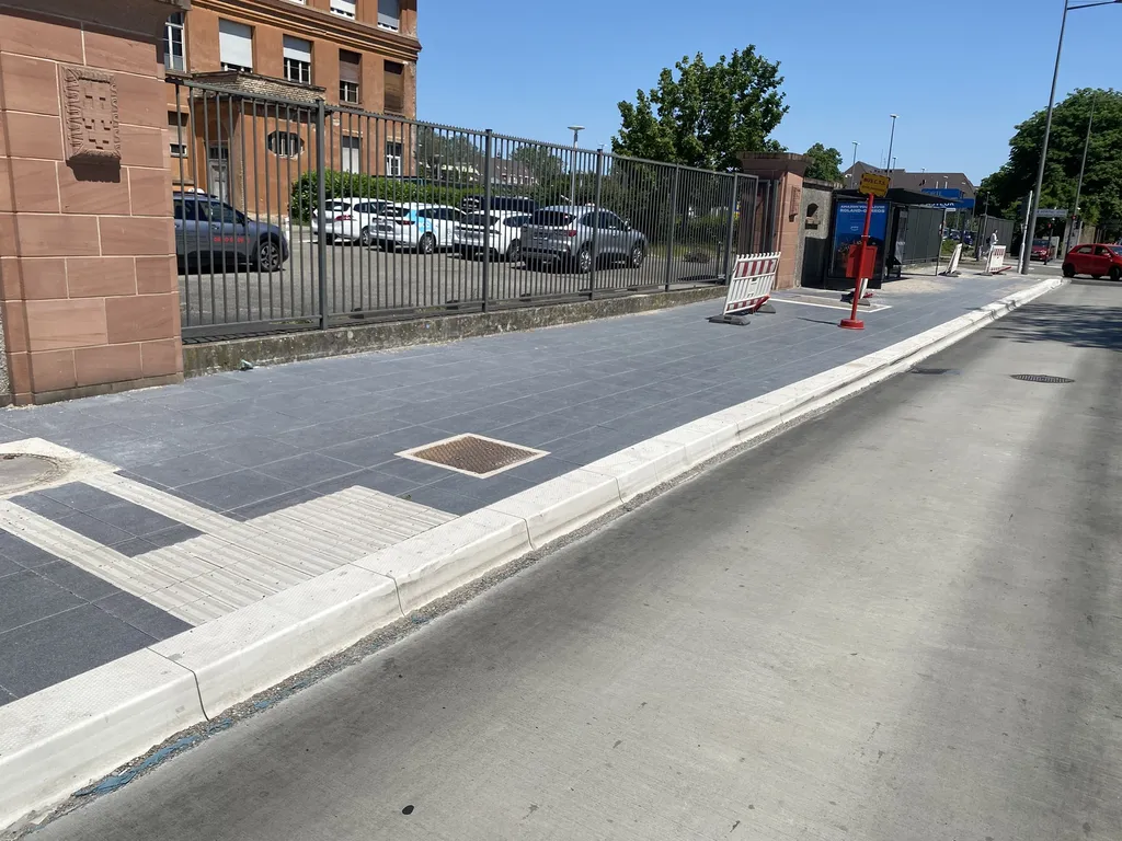 Trottoir urbain neuf avec bordures modernes et aménagement sécurisé en zone résidentielle.
