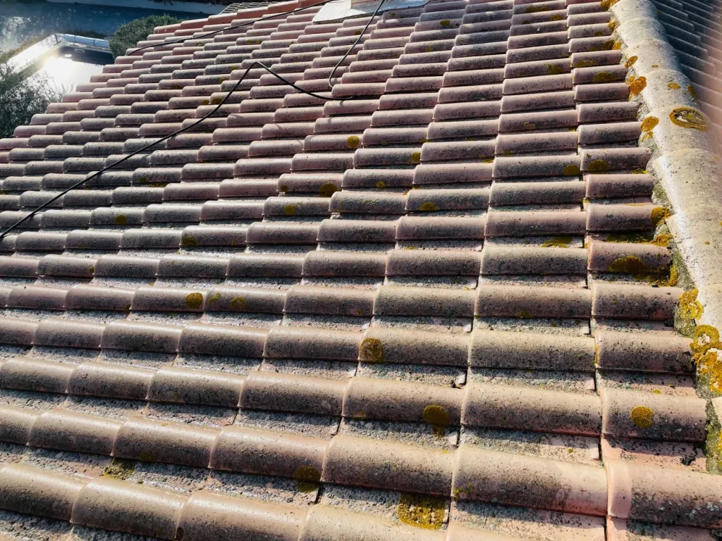 Nettoyage et traitement des tuiles mécaniques Romane d’une toiture de maison près d’Aix en Provence.