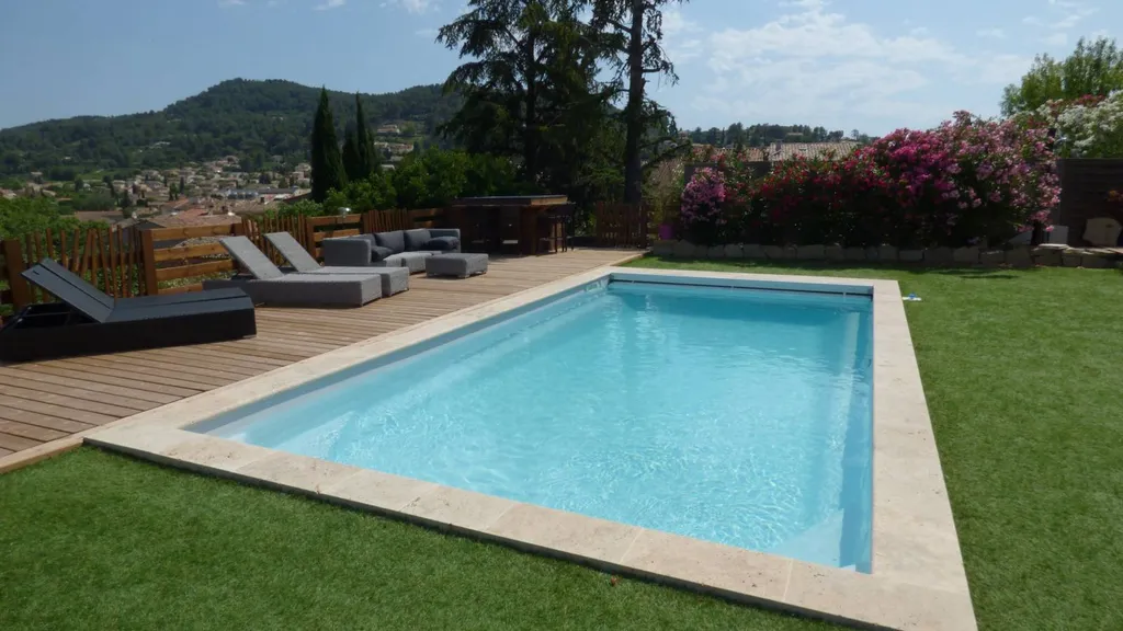 Piscine vue viais dans jardin avec pelouse et margelles