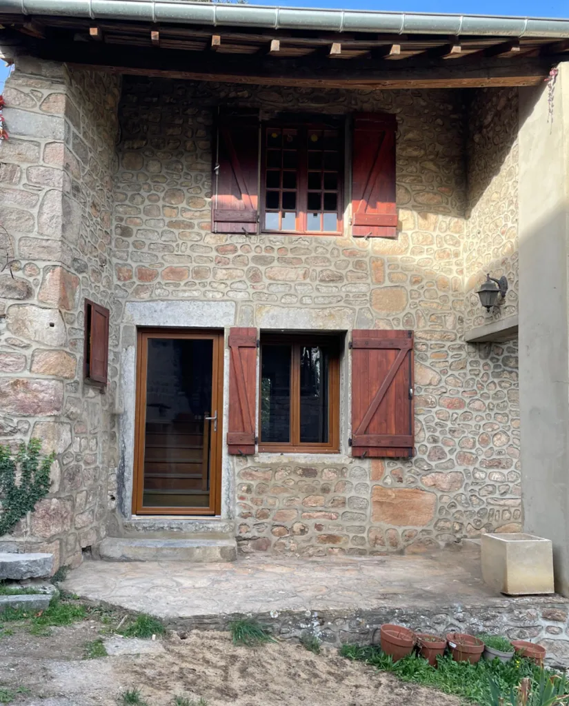 Menuiseries neuves après rénovation énergétique permettant de réduire les déperditions de chaleur et valoriser une maison ancienne à Beaujeu