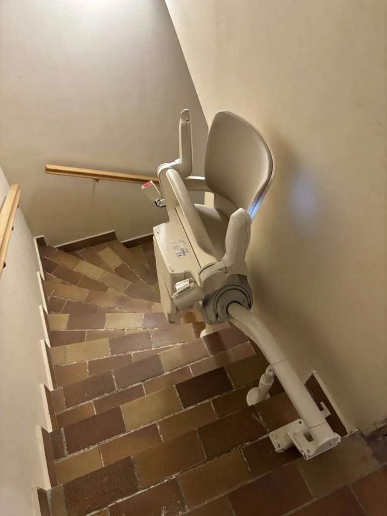 Encombrement minimum dans l'escalier tournant en provenance du garage pour ce fauteuil monte escalier OTOLIFT Smart à Marseille