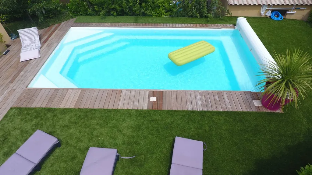 piscine avec volets dans jardin avec pelouse