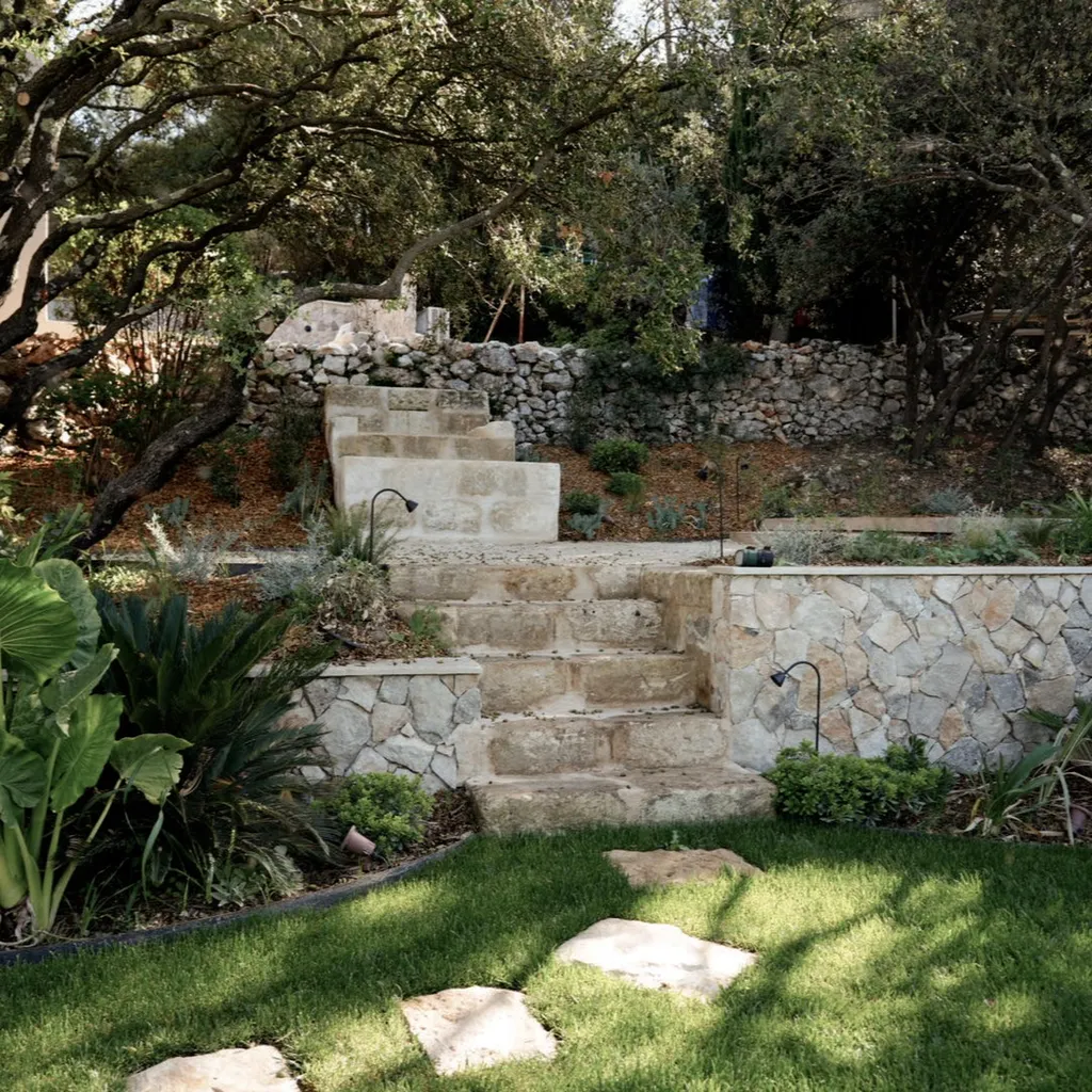 Aménagement extérieur d’un jardin en restanques à Aix-en-Provence avec escaliers en pierre, murs paysagers et végétation méditerranéenne.