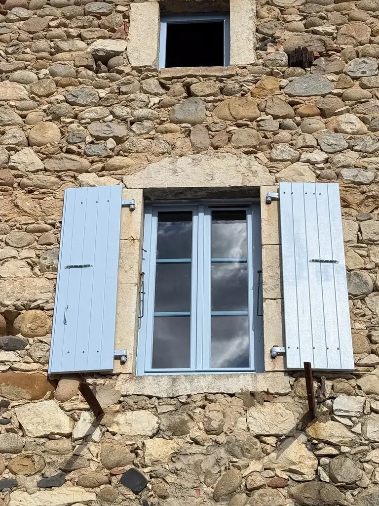 Rénovation de menuiseries bois à Vogüé avec petits bois, volets battants et intégration soignée sur façade ancienne