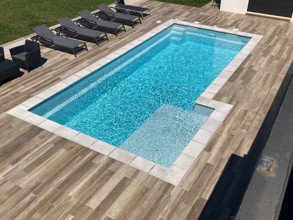 piscine coque avec plage et margelles sur terrasse