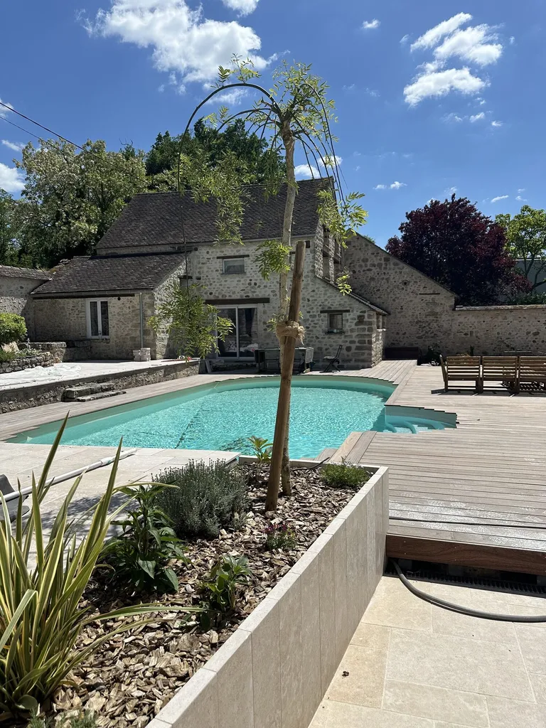 Rénovation des abords d’une piscine à Villemaréchal : terrasse bois, pierre du Sinaï et massifs paysagers