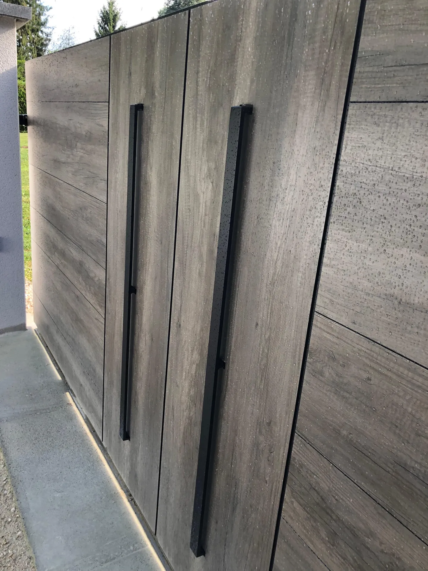 Portail en aluminium ton bois WOODSTOCK bluffant de réalisme assurent une résistance aux UV. La motorisation dans le poteau