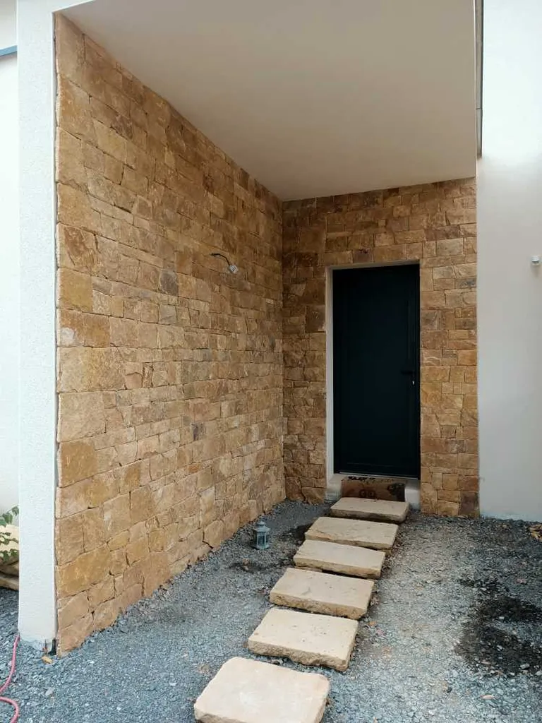 Réalisation d'un habillage de façade avec parement en pierre pour valoriser la maison à Trévoux dans l'Ain