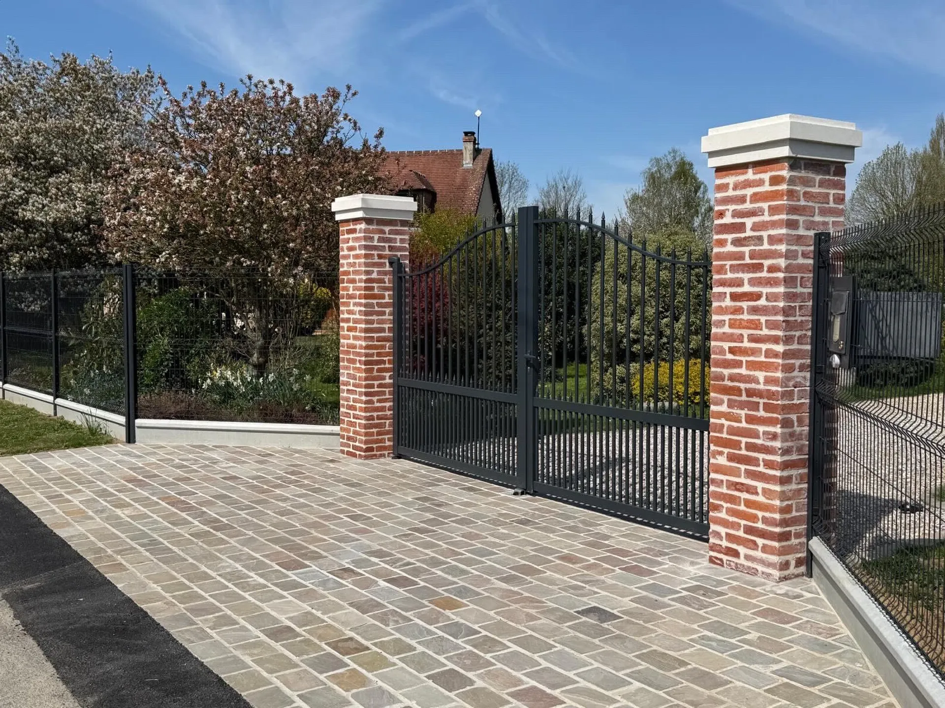 Aménagement extérieur à Tilleul-Othon : piliers en brique, clôture et pavage réalisés par l’entreprise Carême