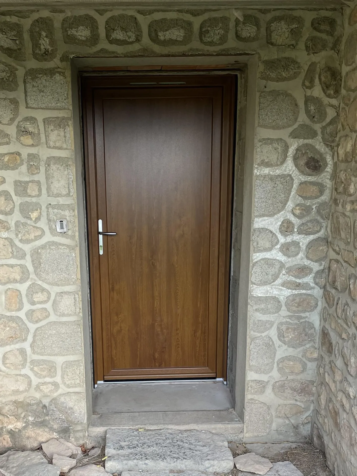 Nouvelle porte d’entrée en PVC vue de l’extérieur améliorant l’isolation thermique, la sécurité et l’esthétique d’une maison à Beaujeu (Rhône 69)