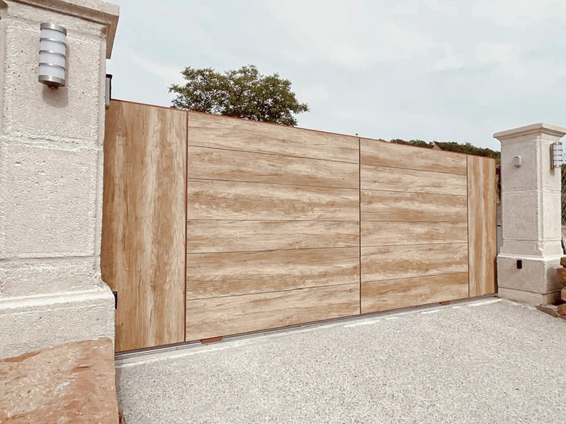 Portail en aluminium ton bois WOODSTOCK bluffant de réalisme assurent une résistance aux UV. La motorisation dans le poteau