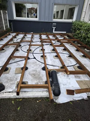 Pose d'un géotextile avec plots PVC réglables en hauteur et lambourdes en pin classe 4 pour terrasse pas chère sur mesure à Eysines