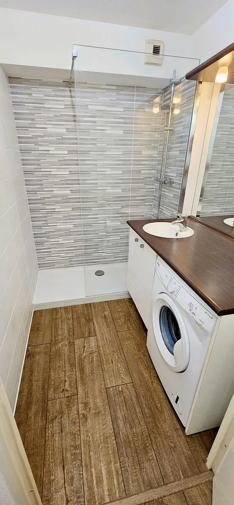 Rénovation et pose de nouveaux revêtements de sols en parquet stratifié chênes foncé en remplacement de l'ancien carrelage existant dans un appartement à Aucamville