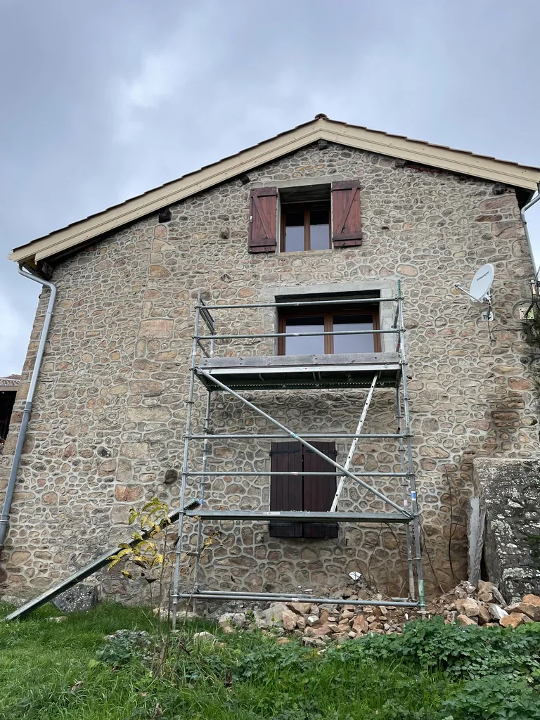 Fenêtre agrandie après pose vue extérieure dans une maison en pierre à Beaujeu (Rhône 69) améliorant la luminosité et le confort thermique