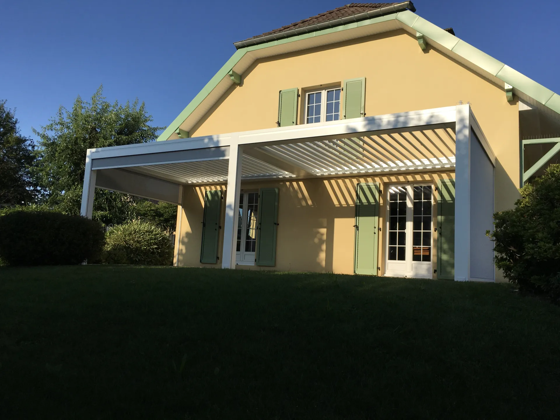Réalisation d’une pergola bioclimatique aluminium double module laqué teinte blanc sablé attenante à Bermont près de Belfort