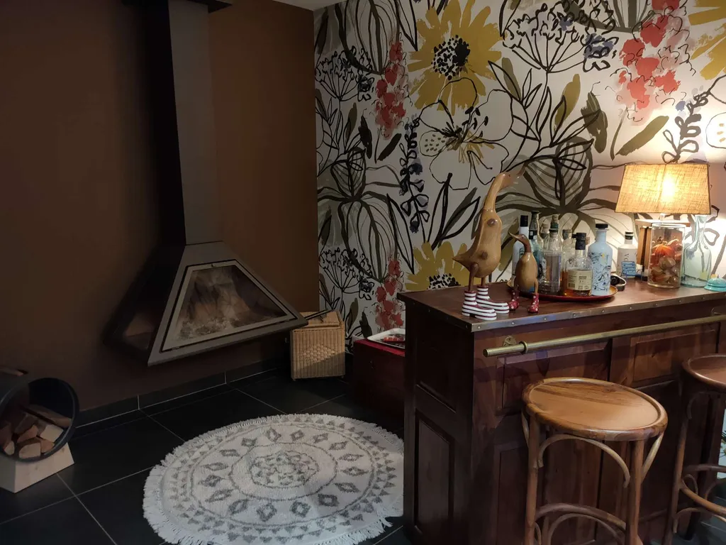 Cheminée métallique suspendue 180° Vyrosa Altéa Fermée sur un mur saumon avec un sol en carreaux gris noir